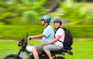 senior couple driving motorcycle with dynamic background