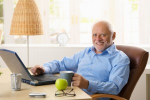 Portrait of happy senior man with computer